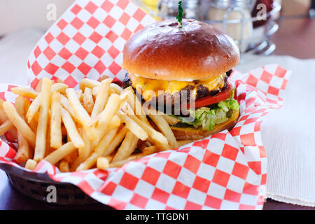 High angle view of burger with French fries served on table in restaurant Stock Photo