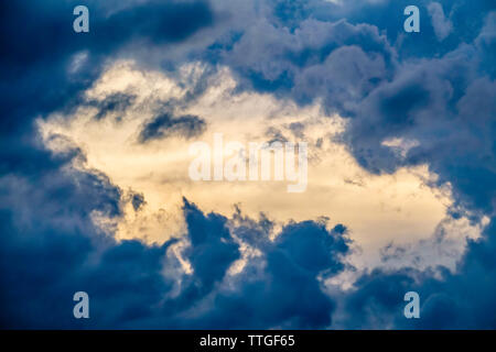 Break in fast-moving storm clouds at sunset near the start of summer Stock Photo