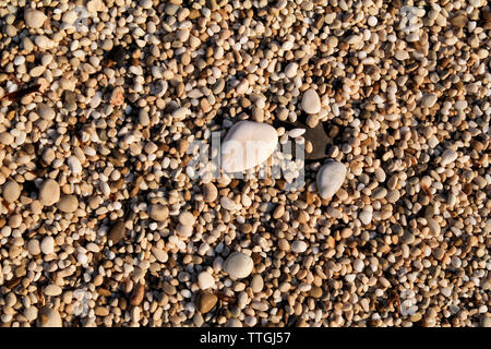 Exotic rocky beach with colorful stones. Texture, material, pattern, background, wallpaper of small multicolored rock sand stone beach. Stock Photo