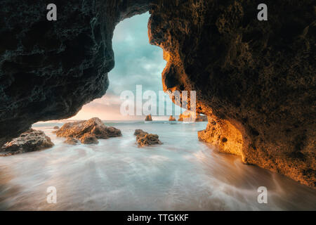 Scenic view of ocean against sky seen through cave Stock Photo