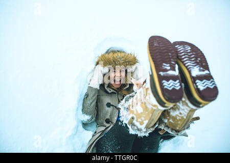 High angle view of woman lying in snow on field Stock Photo