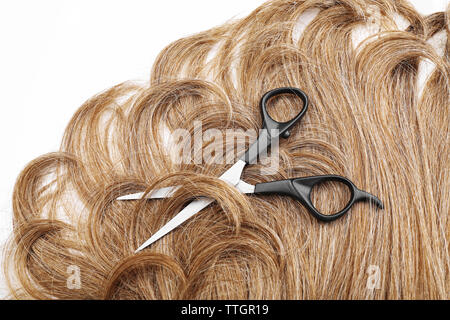 Hairdresser's scissors with brown hair, isolated on white Stock Photo