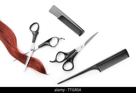 Hairdresser's scissors with combs, strand of red hair, isolated on white Stock Photo
