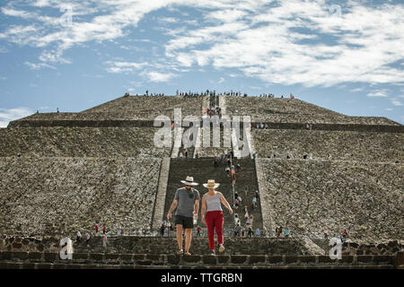 two tourists climb down the pyramid of the sun at teotihuacan mexico