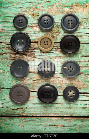 Overhead view of buttons arranged on old wooden table