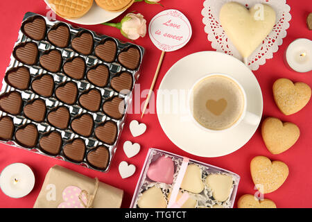 Set of hearts shapes cookies and candies on red table, top view Stock Photo