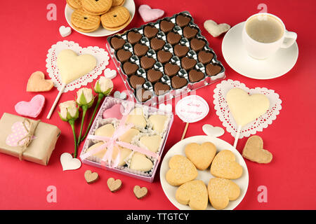 Set of hearts shapes cookies and candies on red table, top view Stock Photo