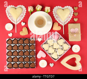 Set of hearts shapes cookies and candies on red table, top view Stock Photo