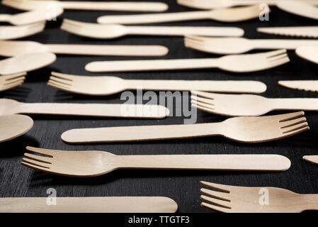 Disposable wooden cutlery on a black table. Stock Photo