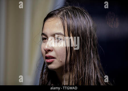 Close view of young woman with water on her face and hair, after rain. Stock Photo