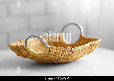 Wicker salver with metal handles on wooden table background, closeup Stock Photo