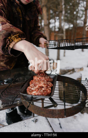 man fries cutlets for burgers. barbecue grill Stock Photo
