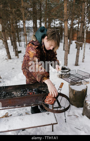 man fries cutlets for burgers. barbecue grill Stock Photo