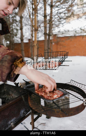 man fries cutlets for burgers. barbecue grill Stock Photo
