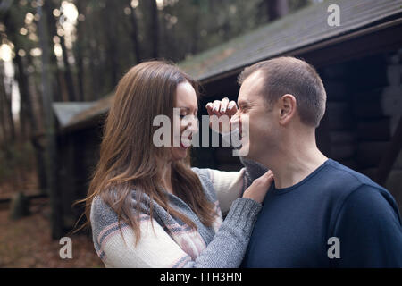 A Married Couple Laughs in Front of a Cabin Stock Photo