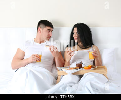Lovely couple having breakfast in bed Stock Photo