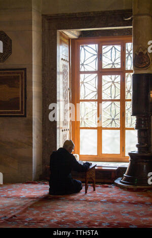 Old man reading Quran in a mosque on display Stock Photo