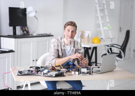 Young man repairing computer hardware in service center Stock Photo