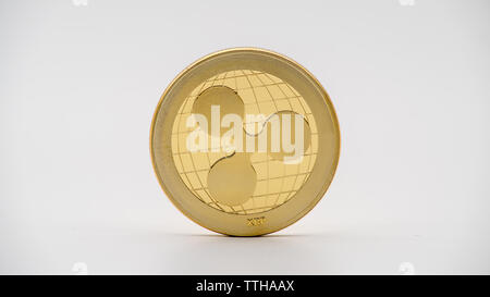 Physical metal golden Ripplecoin currency on white background. New worldwide virtual internet money. Digital Ripple coin cyberspace cryptocurrency XRP Stock Photo