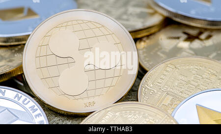 Physical metal golden Ripplecoin currency over others coins. Worldwide virtual internet money. Digital Ripple coin in cyberspace, cryptocurrency. Stock Photo