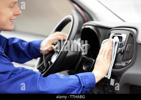 Young man polishing vehicle interior Stock Photo