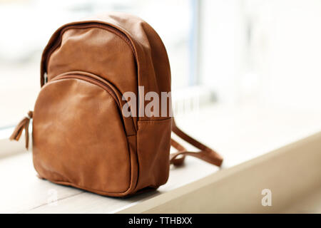 Brown leather backpack on the windowsill. Stock Photo