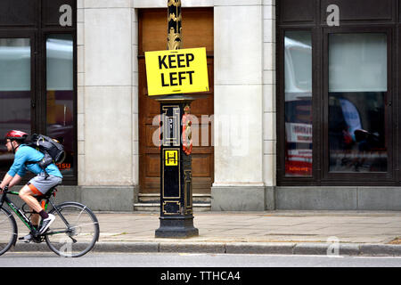 London, England, UK. Keep Left sign in Fleet Street. Cyclist passing by Stock Photo