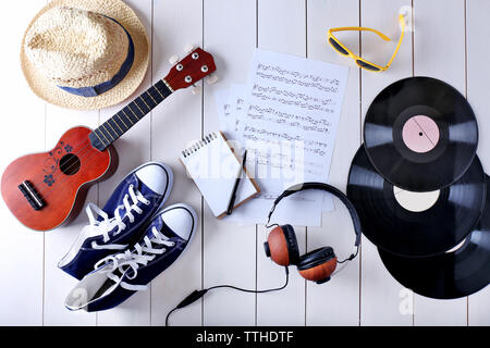 Musical accessories with sunglasses, hat and gumshoes on wooden surface, top view Stock Photo