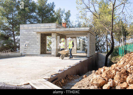 Site manager giving instructions to a mason on the construction site of a house under construction Stock Photo