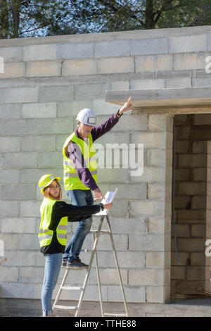 Young trainee woman with her tutor on a construction site visit, building trades Stock Photo