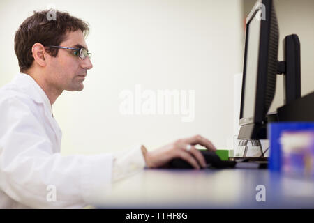 Side view of dentist using computer at clinic Stock Photo