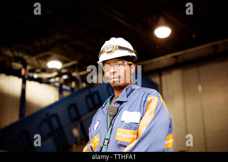Portrait of male worker standing in illuminated recycling plant Stock Photo
