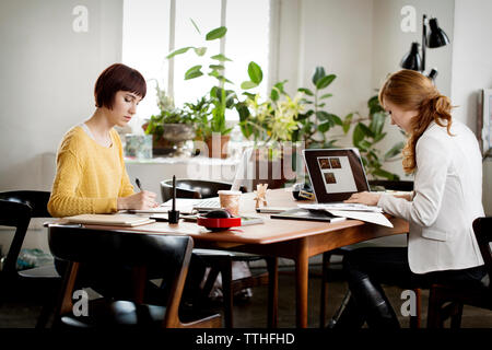 Female photo editors working at table in creative office Stock Photo
