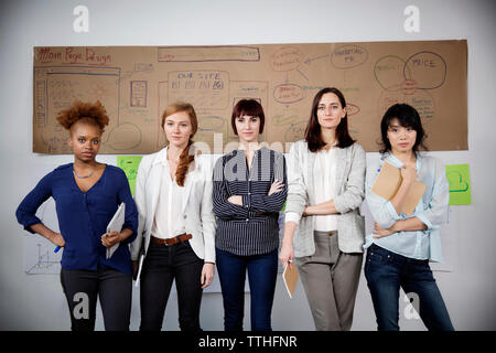 Portrait of confident businesswomen standing in creative office Stock Photo