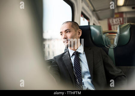 Thoughtful businessman traveling in train Stock Photo