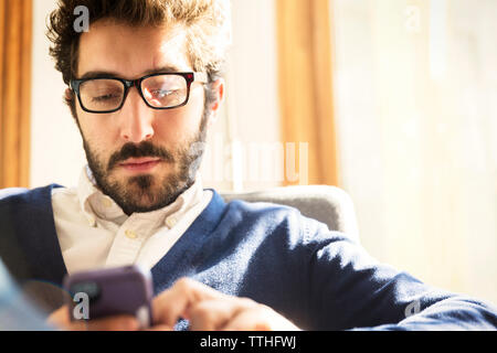 businessman using phone while sitting at home Stock Photo