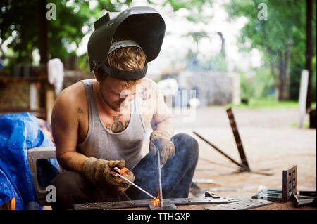 Concentrated worker welding outside workshop Stock Photo