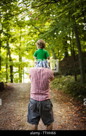 Back View of Father and Son on Dirt Road with Fishing Gear - Stock