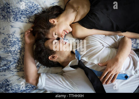 Overhead view of smiling couple relaxing on bed Stock Photo