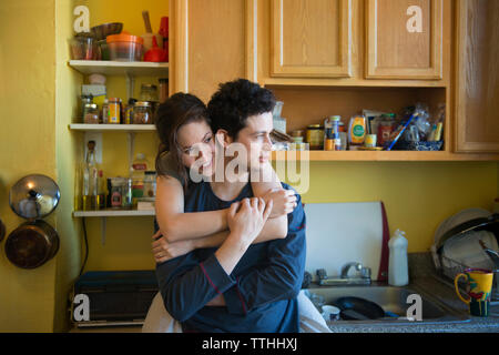 Happy couple standing in kitchen Stock Photo