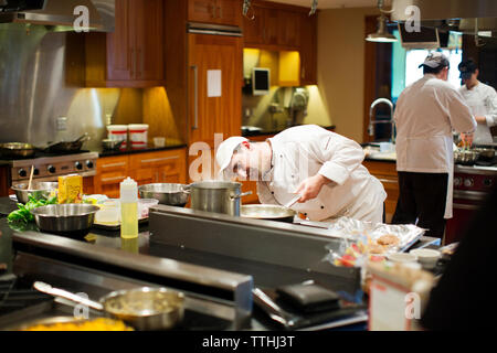 Chefs preparing food at commercial kitchen Stock Photo