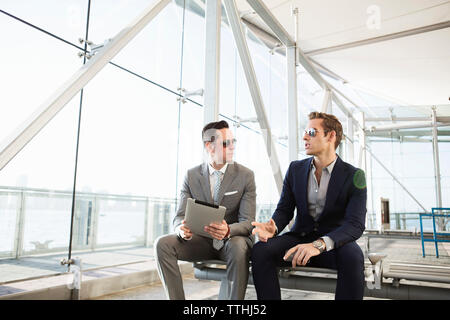 businessman having discussion while holding tablet computer at transportation building Stock Photo