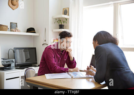 business people having discussion over documents at desk in creative office Stock Photo