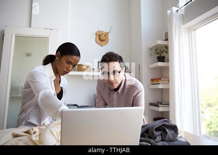 Fashion designers discussing over laptop at desk in design studio Stock Photo