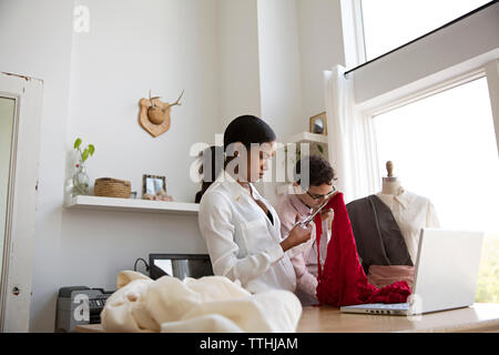 Fashion designers working at desk in design studio Stock Photo