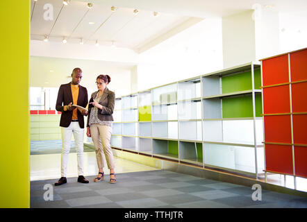 business colleagues having discussion while standing in creative office Stock Photo