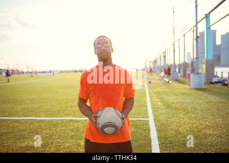 Portrait of sportsman with ball standing on soccer field Stock Photo