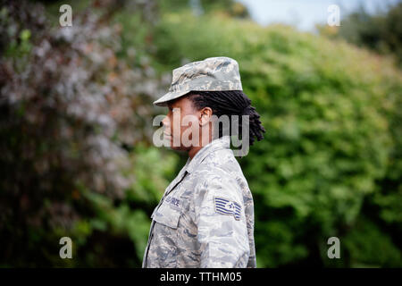 Profile view of female soldier standing against trees Stock Photo