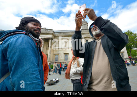 London, England, UK. Elderly West Indian man taking a selfie in Trafalgar Square Stock Photo