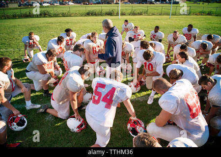 High angle view of coach giving training to players on American football field Stock Photo